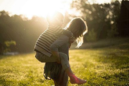 photo of siblings, one carrying the other